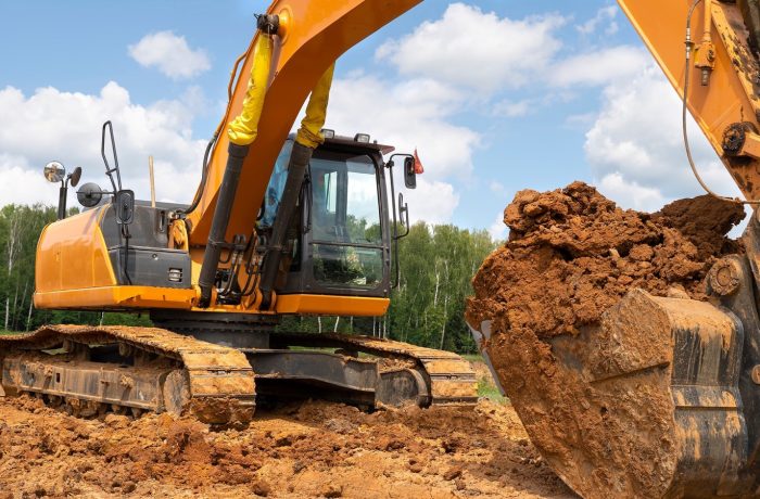 Excavator bucket full of soil on a dig site