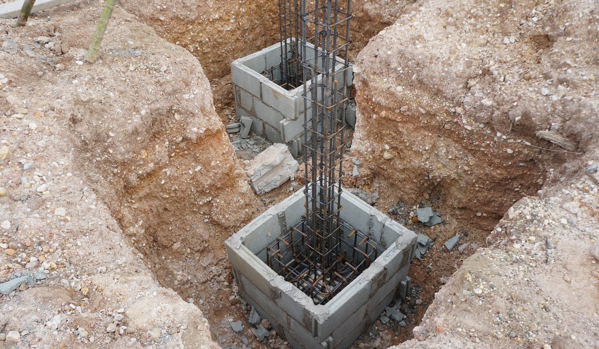 Rebar-reinforced concrete block footings in excavated pits
