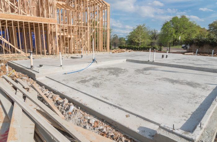 Concrete slab-on-grade foundation beside a framed house