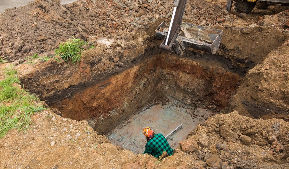 Worker in a deep excavation for a septic tank