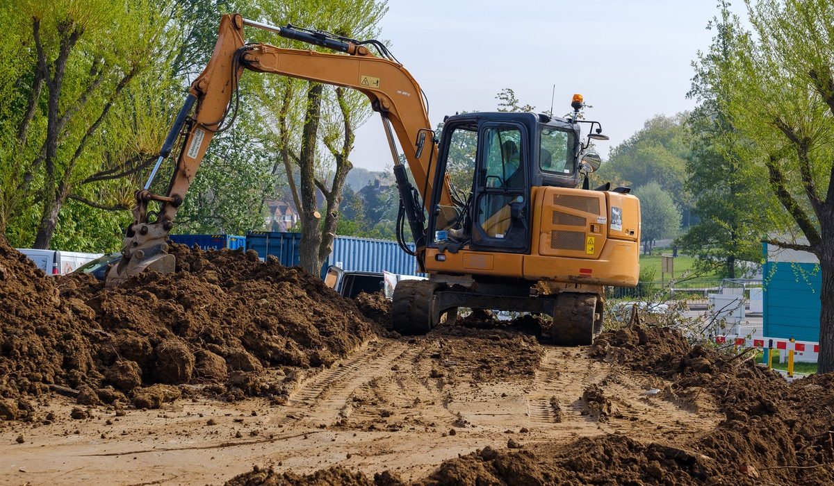 Tracked excavator moving earth on a construction site