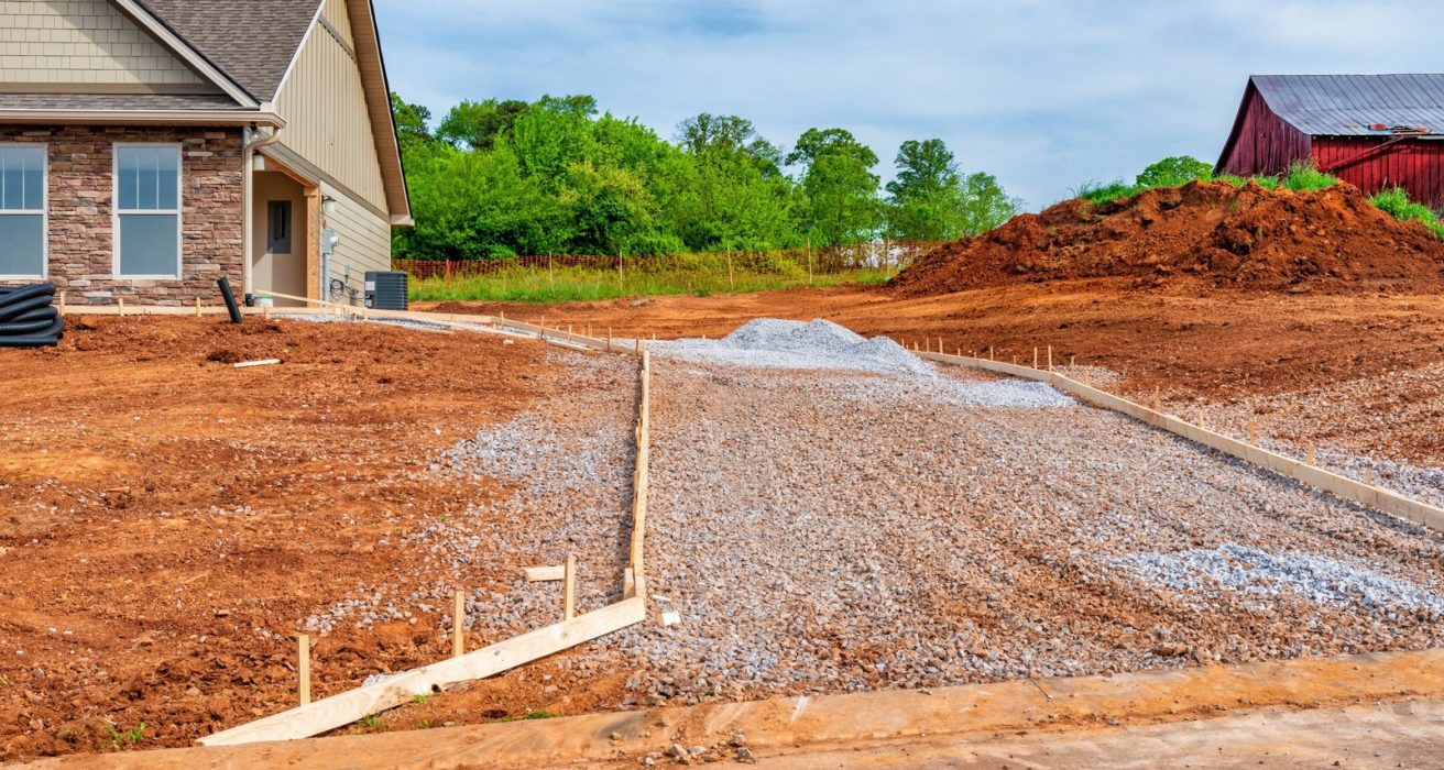 Gravel driveway base prepared beside a new house