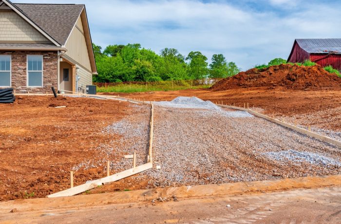 Gravel driveway base prepared beside a new house
