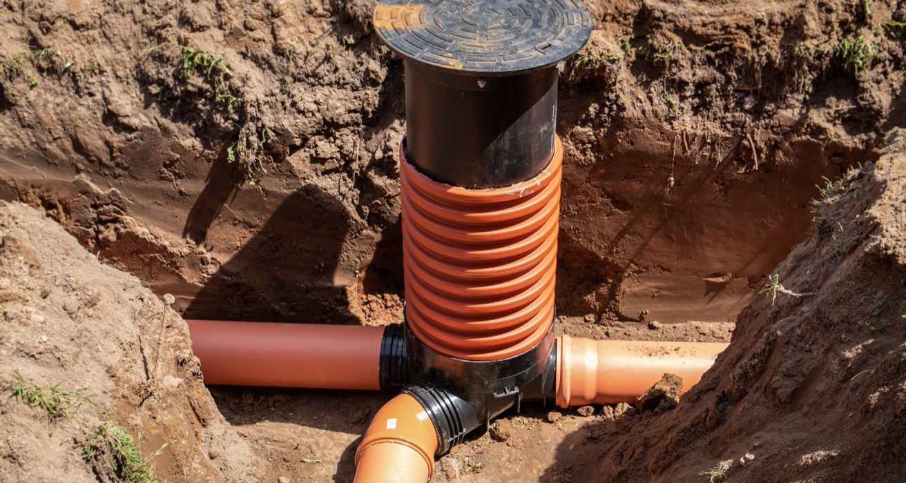 Sewer pipe tie-in with an inspection riser in an open trench
