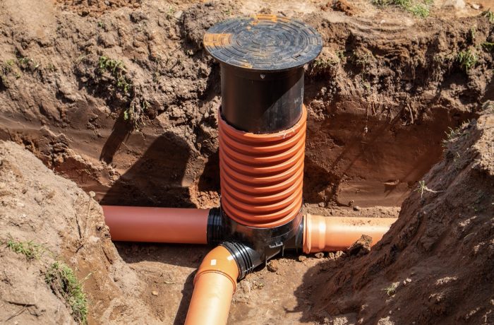 Sewer pipe tie-in with an inspection riser in an open trench